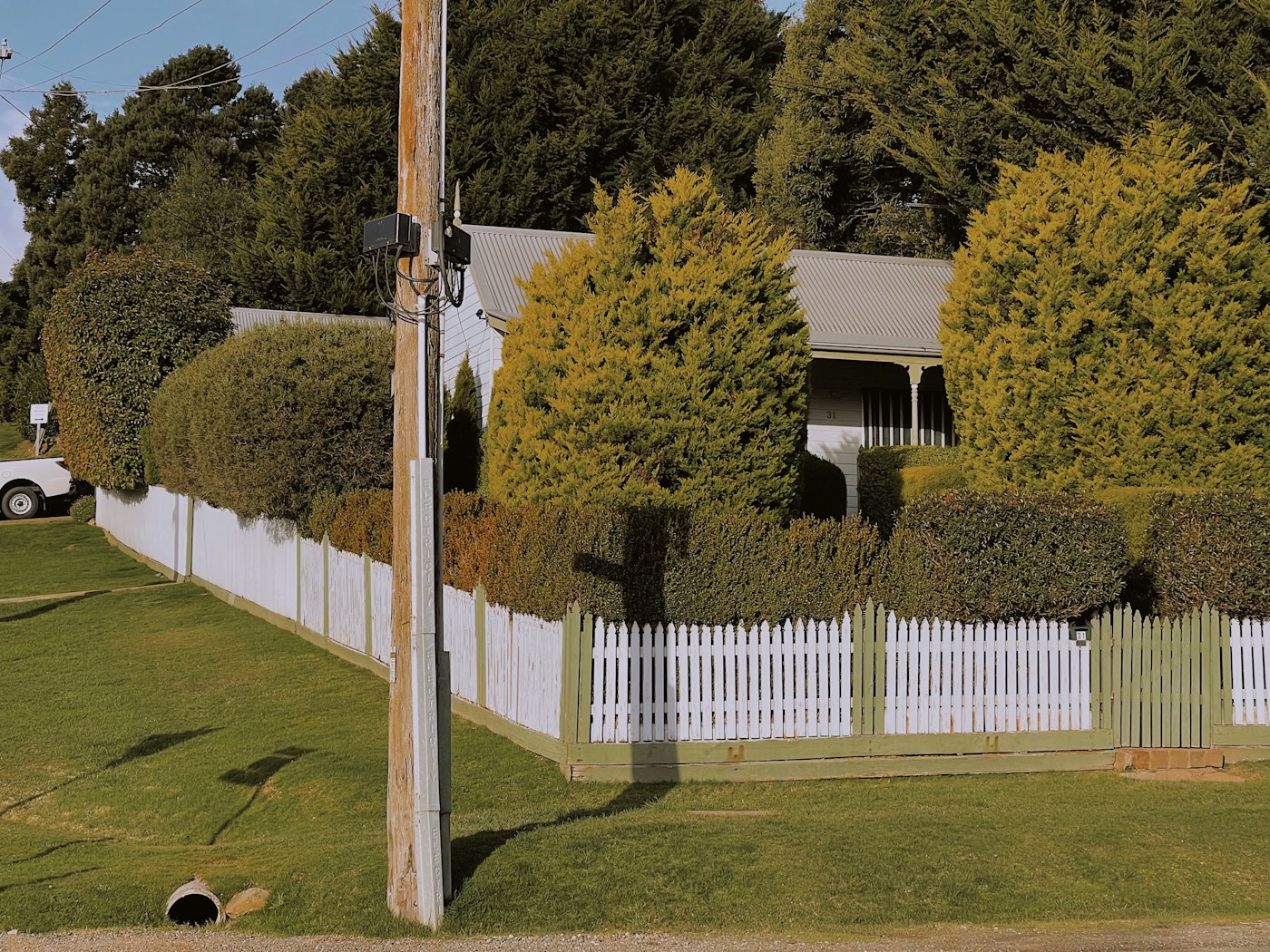 White picket fence in front of a country home